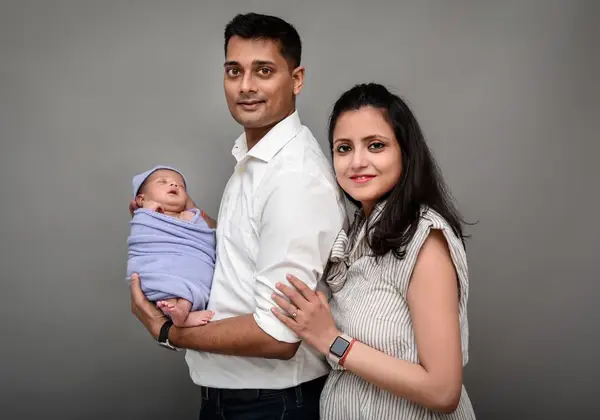 New parents holding their newborn close