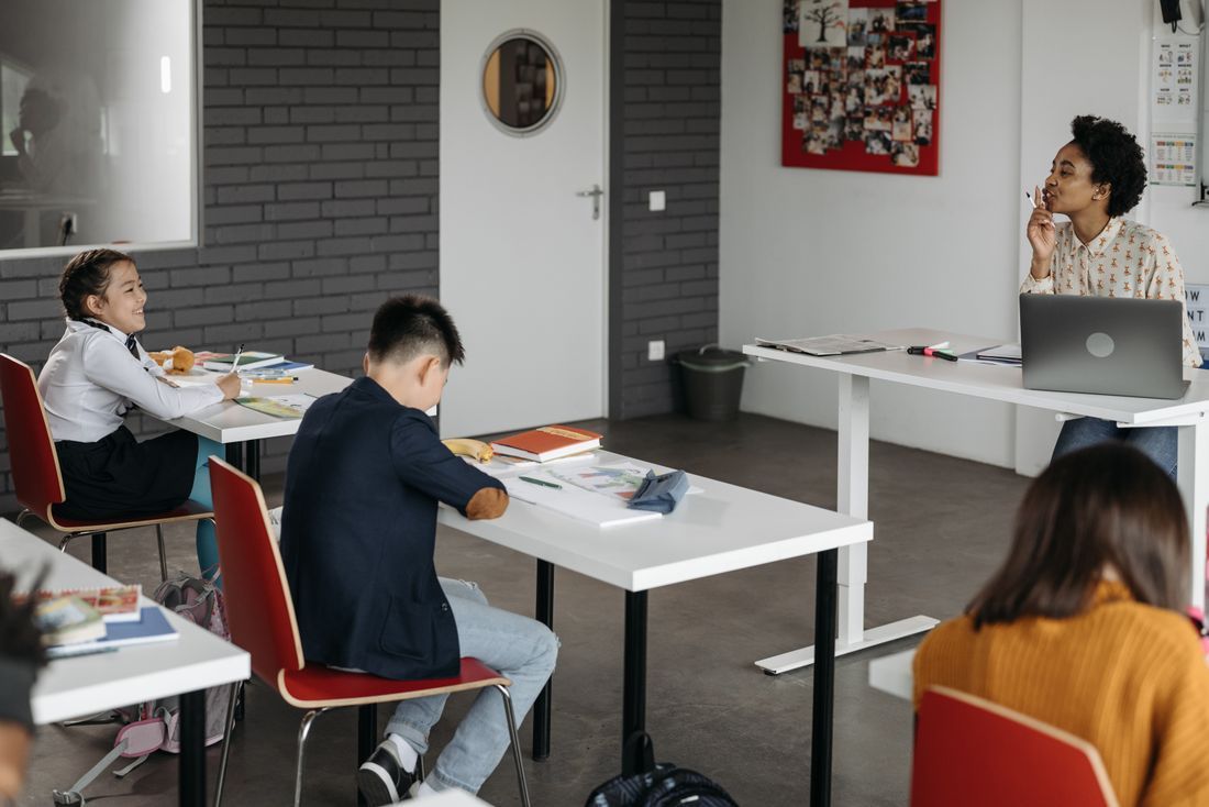 A teacher at her desk while students work quietly