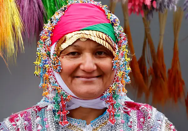 A smiling Turkish woman in traditional dress