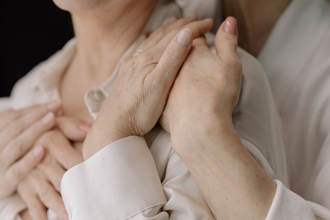 Older hands clasped tenderly in an embrace