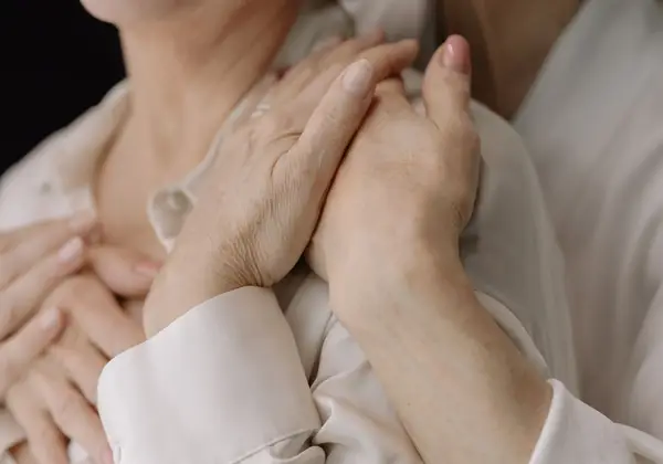 Older hands clasped tenderly in an embrace