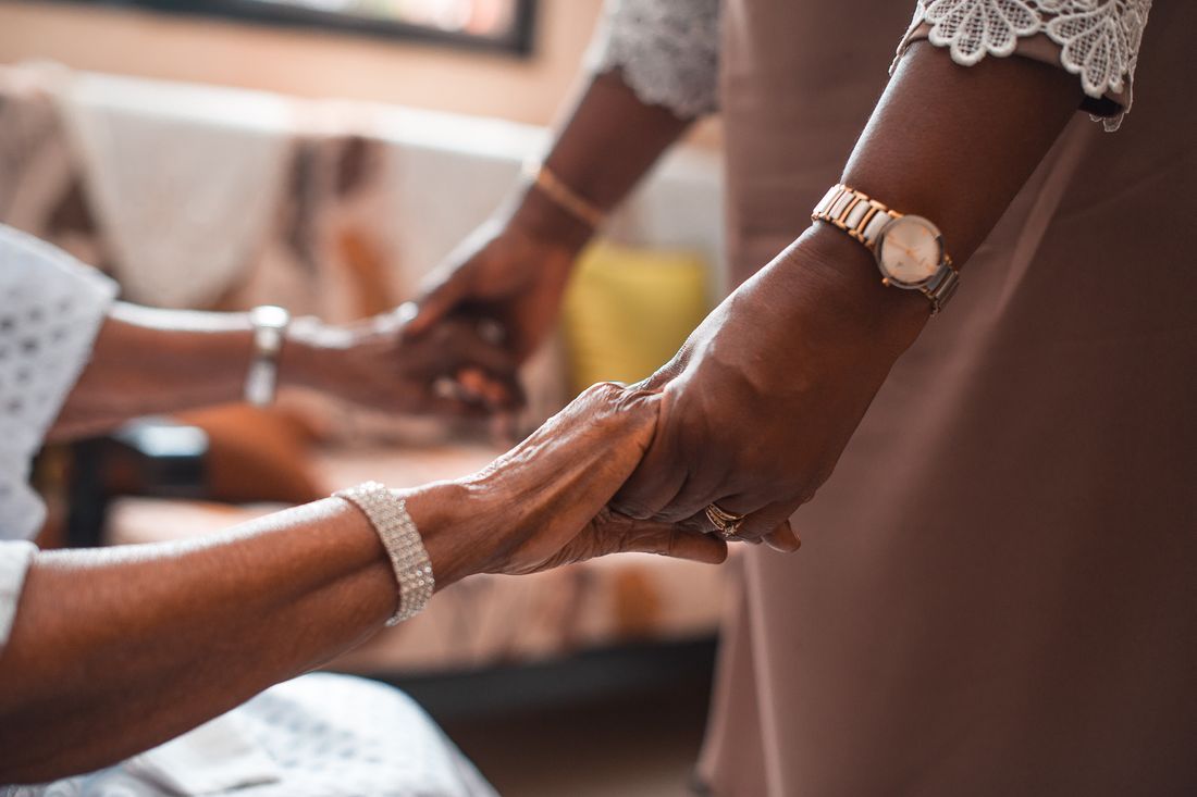 Two people holding hands in comfort