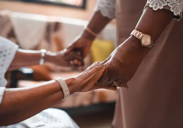 Two people holding hands in comfort