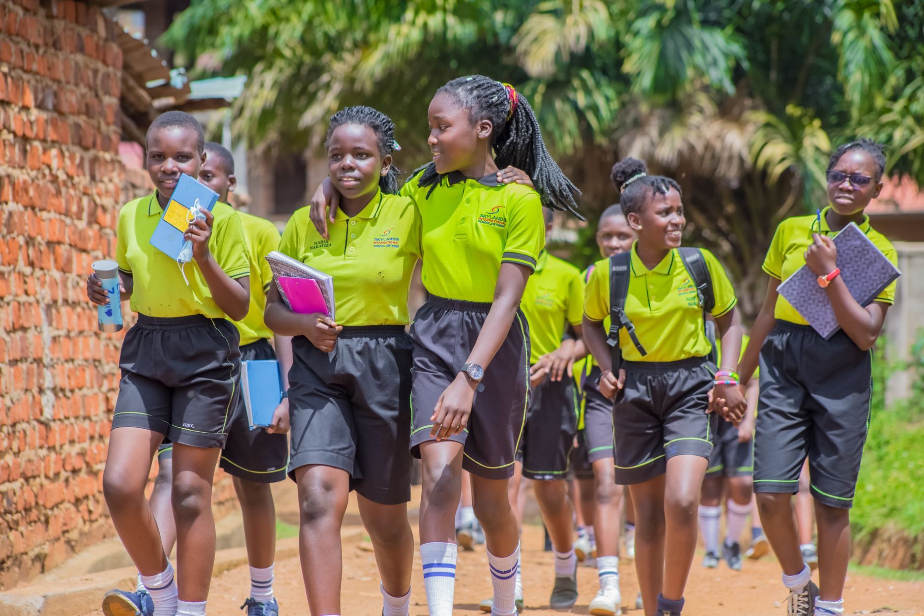 Smiling Ugandan students walking to school