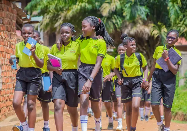 Smiling Ugandan students walking to school