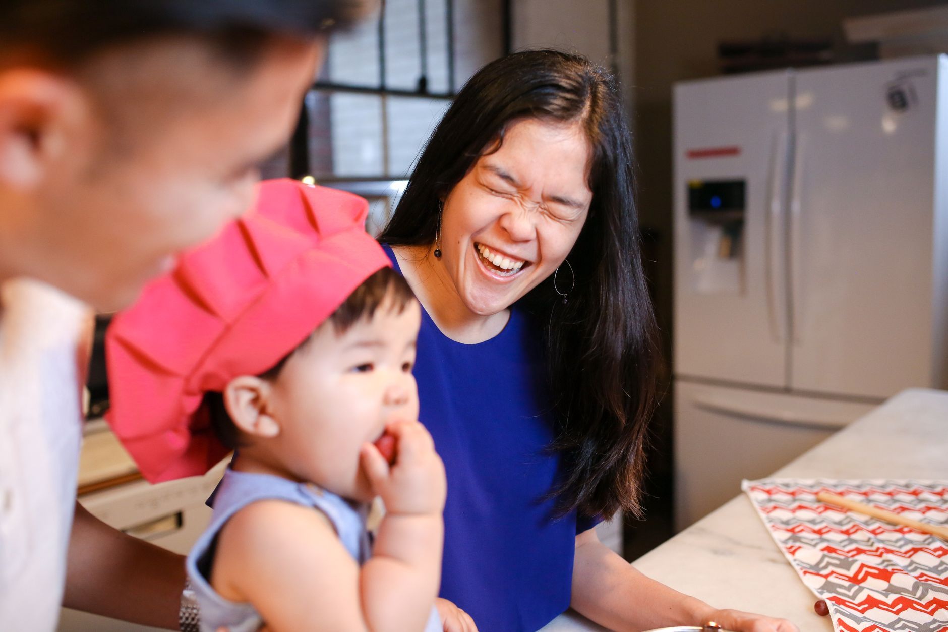 A Korean family laughing together at home