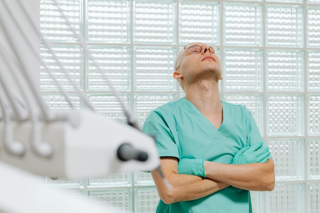 A doctor pausing with eyes closed at the limit of a long day