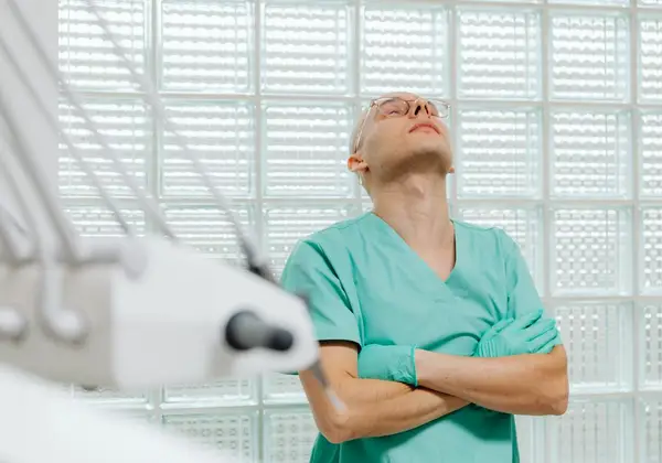 A doctor pausing with eyes closed at the limit of a long day