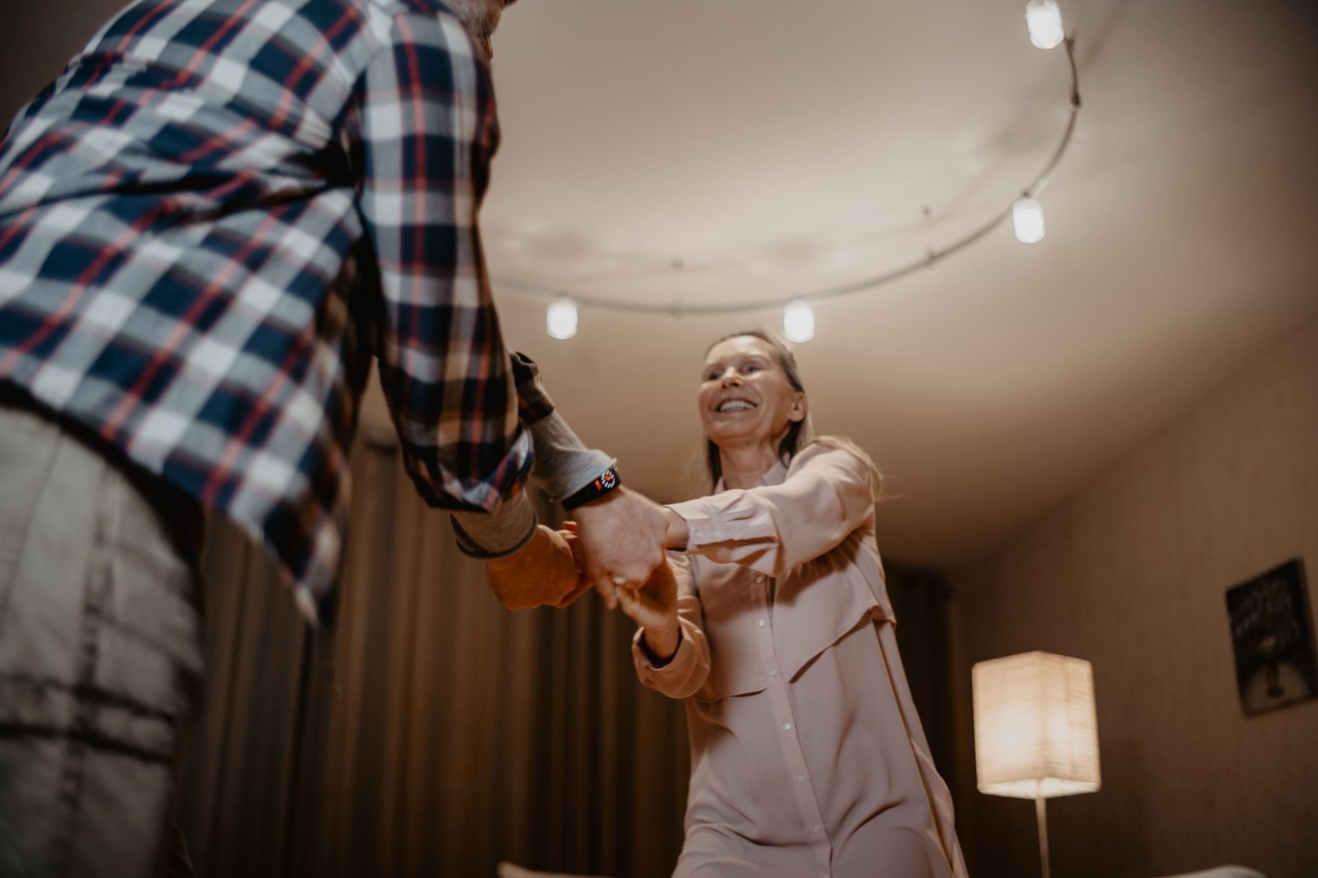 A couple dancing together under warm string lights