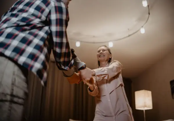 A couple dancing together under warm string lights
