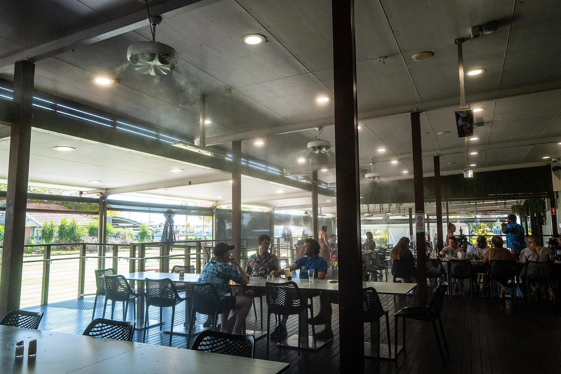 Evaporative cooling unit installed outdoors at a sports club, showing a real pad-and-fan installation.
