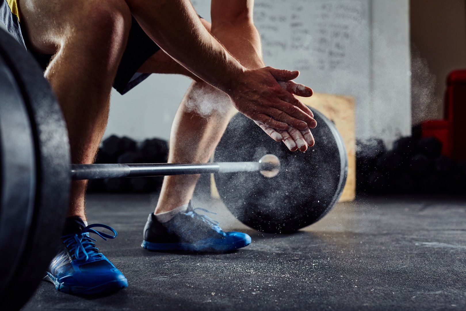 en man utan skjorta lyfter en hantel i ett gym