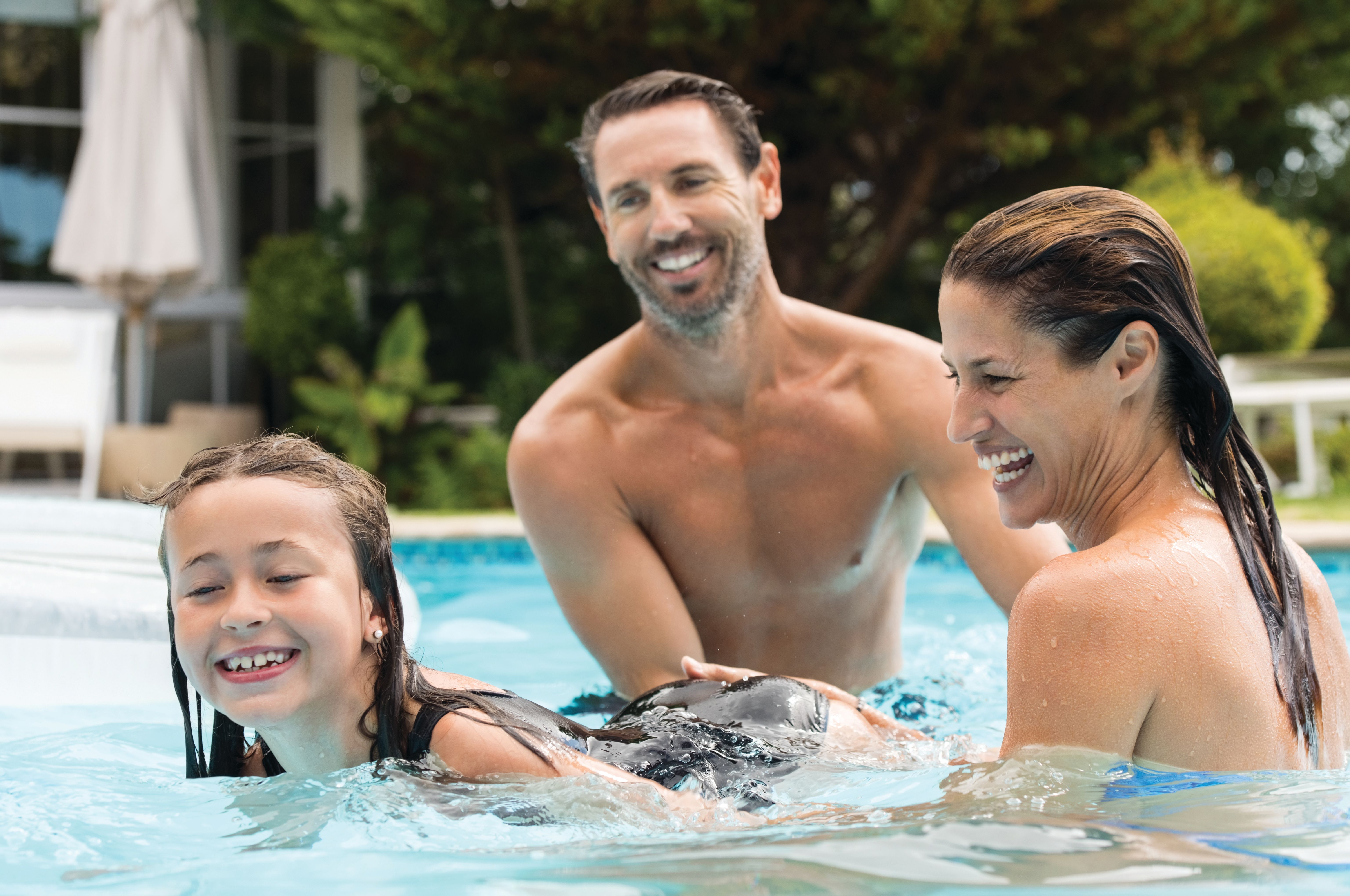 Family laughing and playing together in one of the community pools in North River Ranch, enjoying a sunny Florida day.