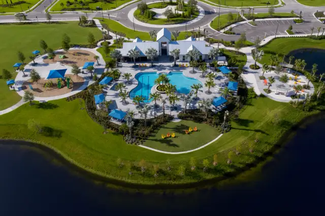 Aerial view of the Brightwood Pavilion amenity campus at North River Ranch, featuring a resort-style pool, clubhouse, playground, walking paths, and landscaped outdoor gathering spaces.