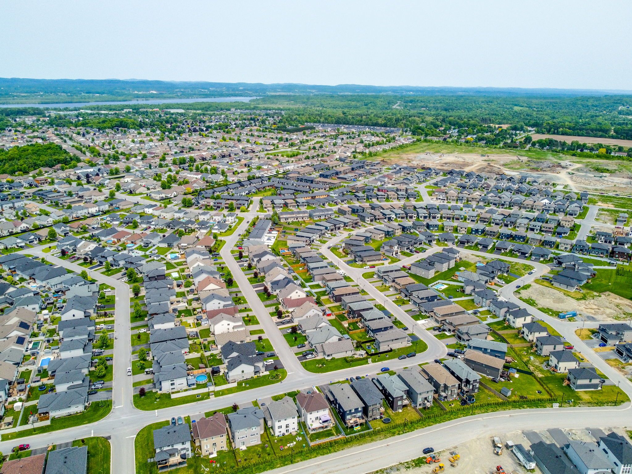 Aerial view of Morris Village in Rockland, Ontario, showing established neighbourhoods, new homes under construction and the Ottawa River in the distance.