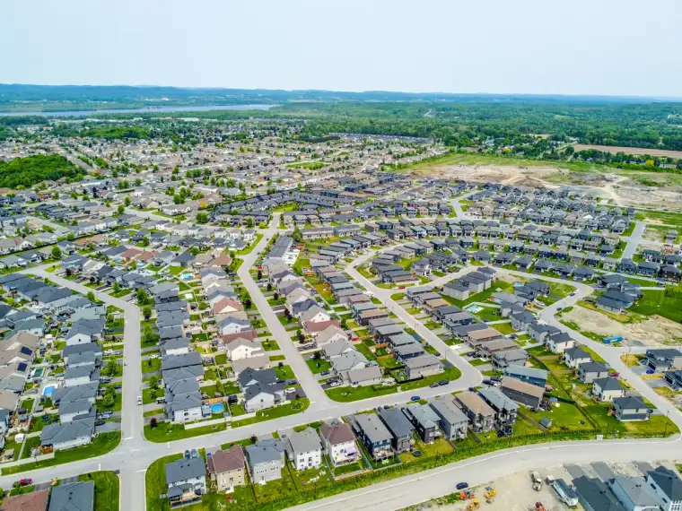 Aerial view of Morris Village in Rockland, Ontario, showing established neighbourhoods, new homes under construction and the Ottawa River in the distance.