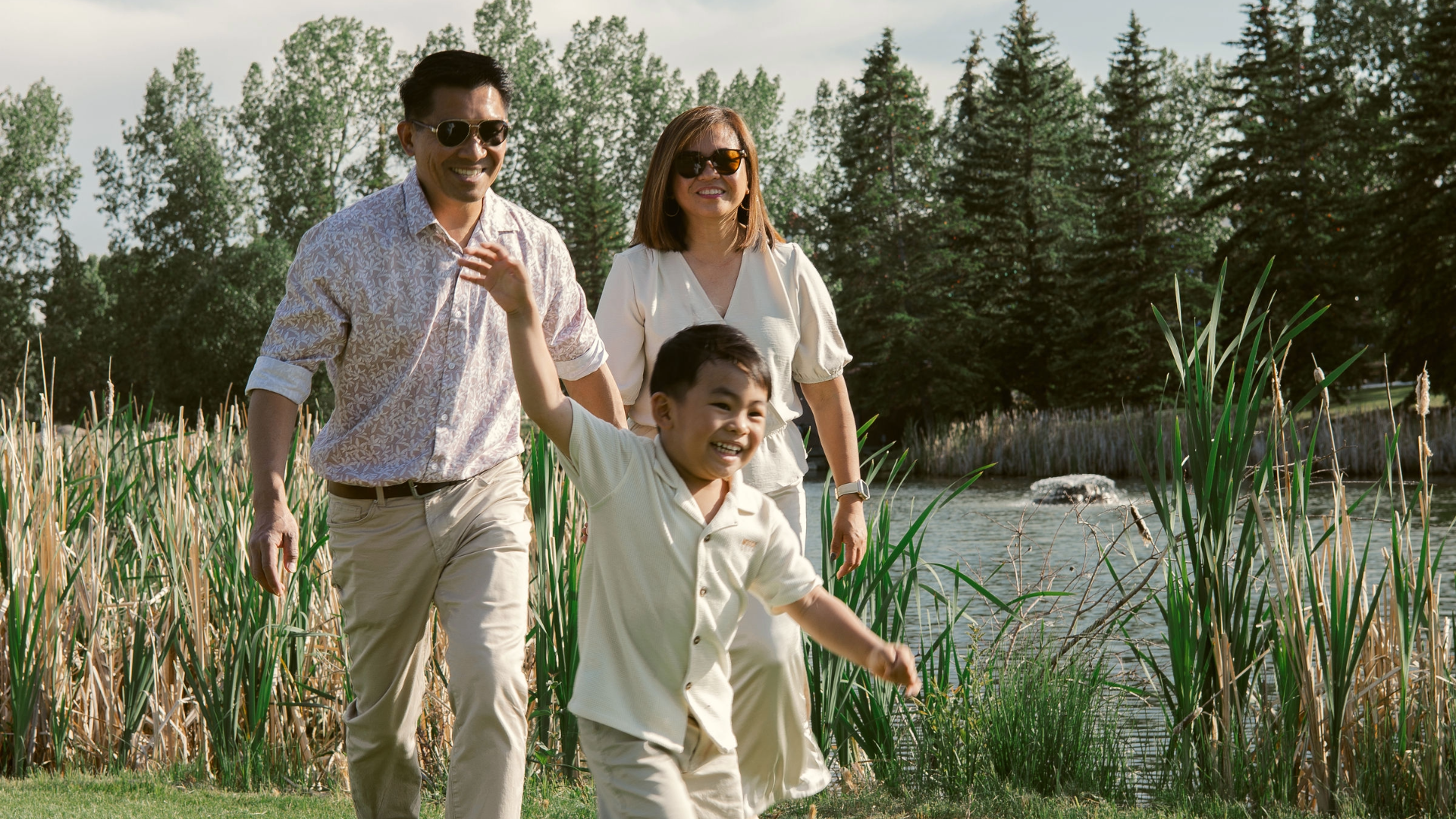 Family walking beside a wetland and green space in the Silverton community in southwest Calgary.