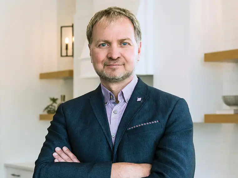Richard Bukarewicz wearing a suit is positioned in a contemporary kitchen.