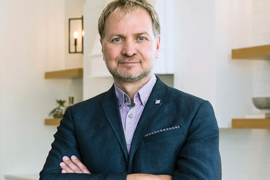 Richard Bukarewicz wearing a suit is positioned in a contemporary kitchen.