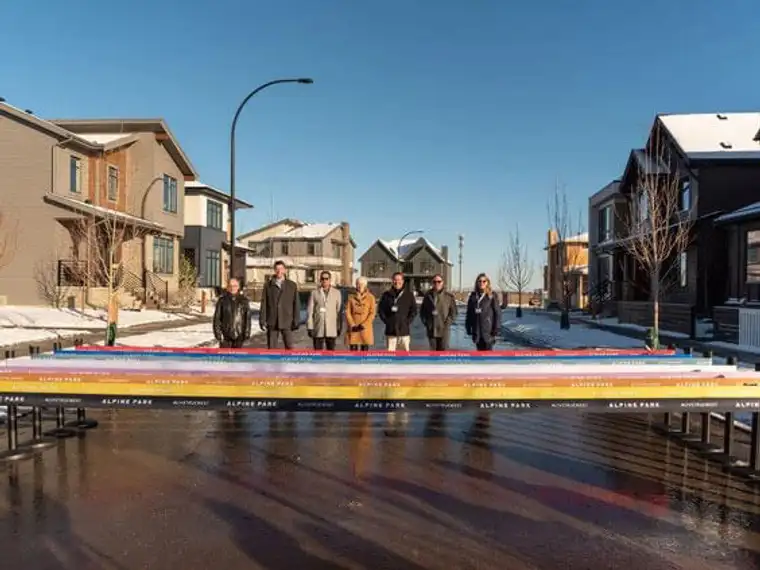 A group of individuals pose facing down the street.