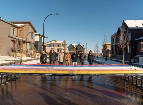 A group of individuals pose facing down the street.
