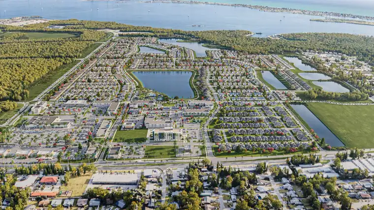 Aerial view of the SeaFlower community in Parrish, Florida, showing new homes, community lakes, green space, and the nearby coastline.