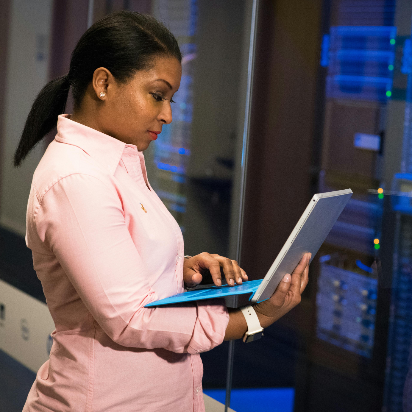 Female security expert looking at laptop in data warehouse.