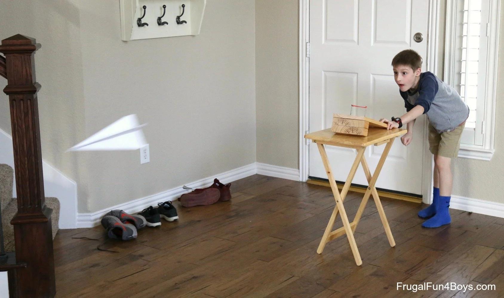 A boy launching a paper airplane
