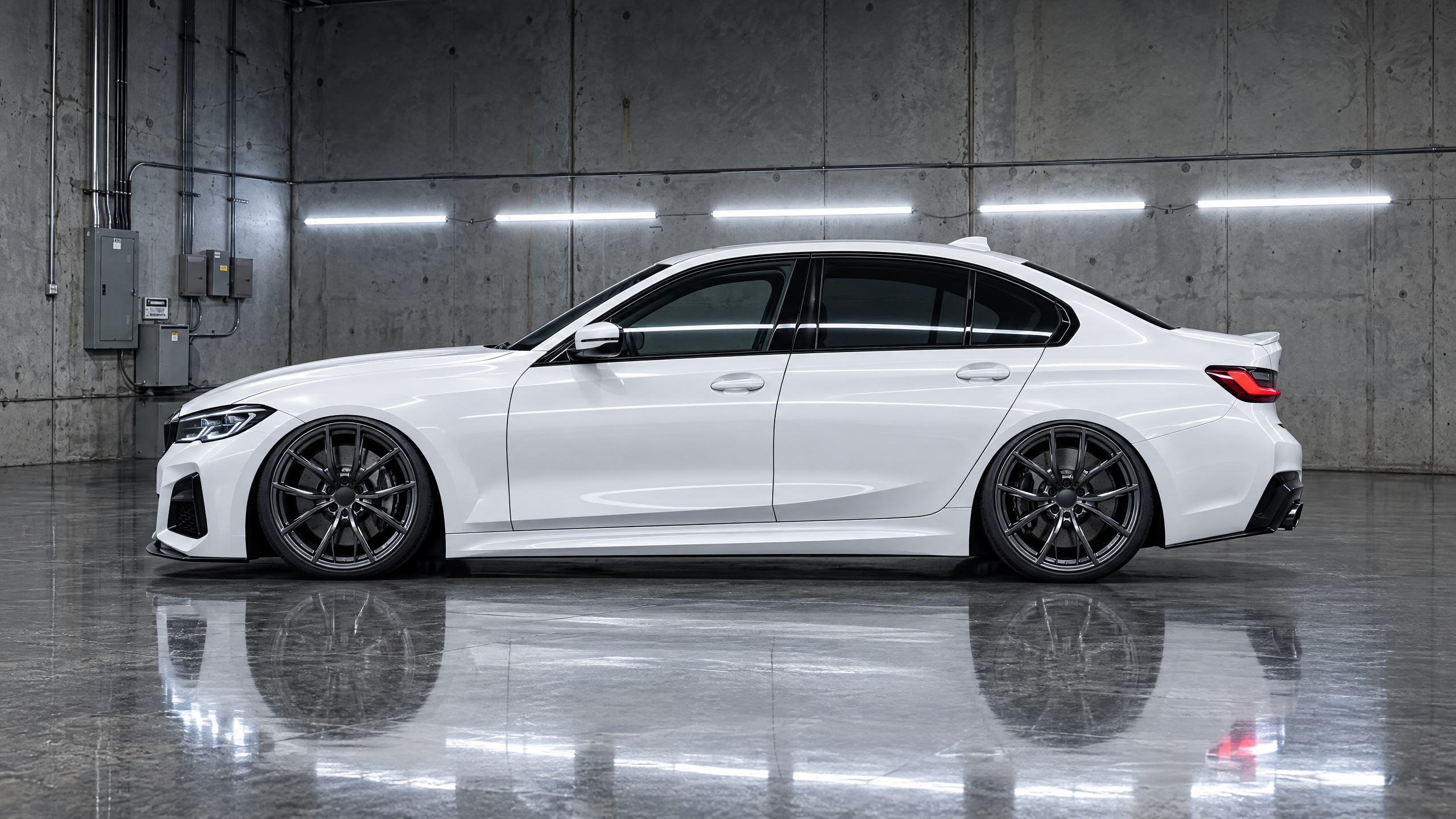 Custom gloss liquid smoke wheels paired with a dialed suspension ride height on an alpine white sedan in Houston, TX. Precision stance tuning and flush fender fitment.