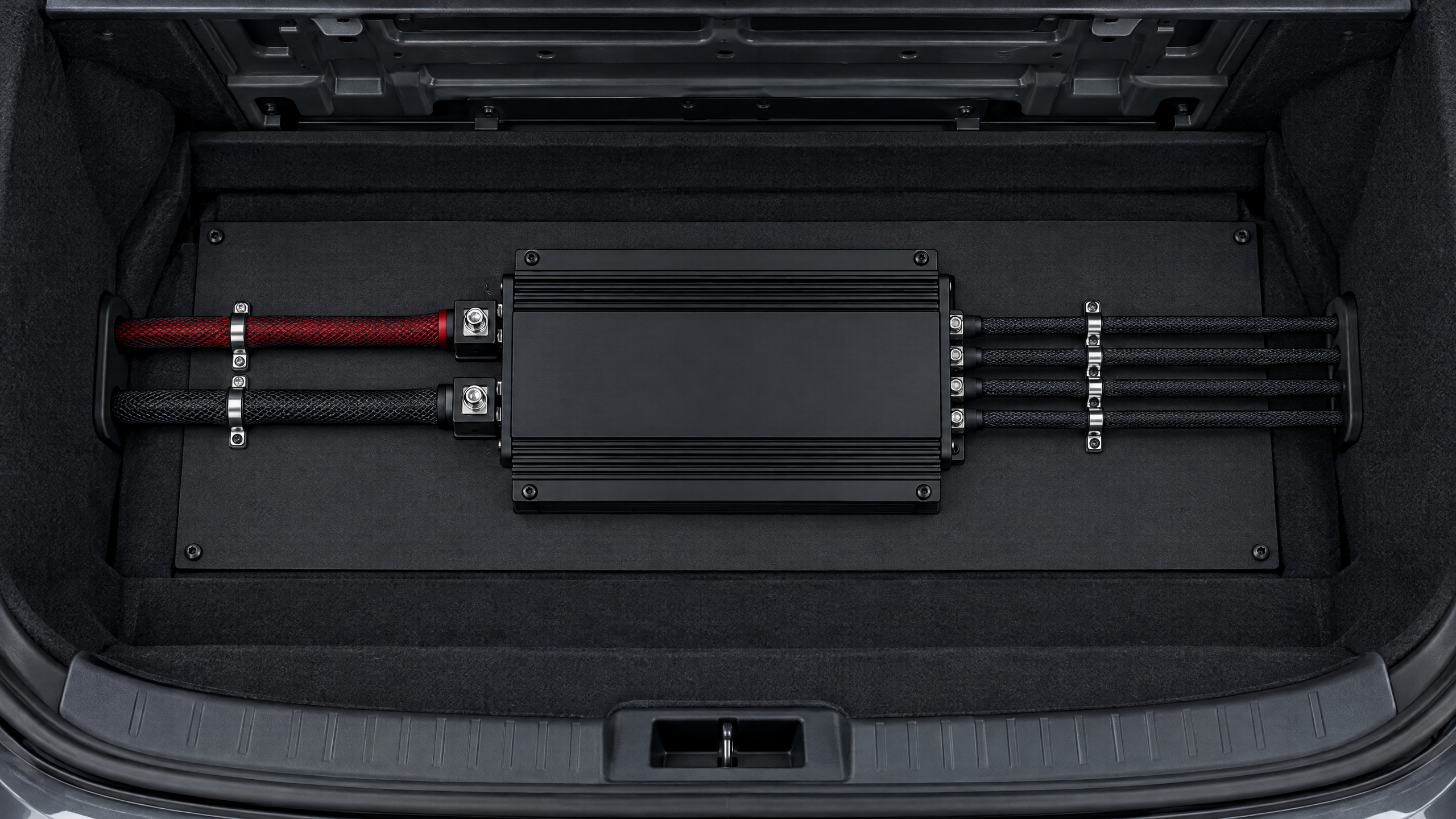 Custom car amplifier rack fabrication and electrical wire routing in Texas. Stealth under-floor amplifier mounts with braided mesh wire sleeving and metal P-clips serving Houston, Spring, and Cypress.