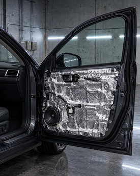 Automotive sound deadening and acoustic dampening installation in Houston. High-grade foil-backed butyl door panel treatment to stop panel vibration and road noise for luxury cars and trucks in Texas.
