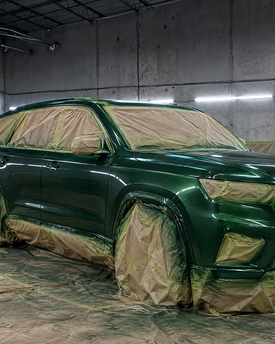 Complete vehicle respray and custom color change services in Texas. A heavy-duty off-road truck fully prepped, masked, and receiving a flawless custom base coat inside our in-house paint booth. High-end automotive refinishing for Houston, Sugar Land, and beyond.