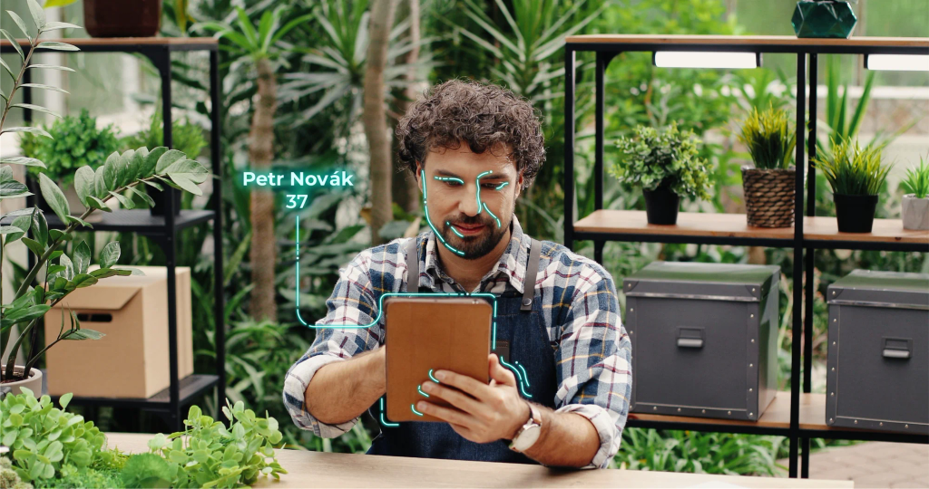 A person verifies their identity with a selfie on a tablet, with a face-matching overlay