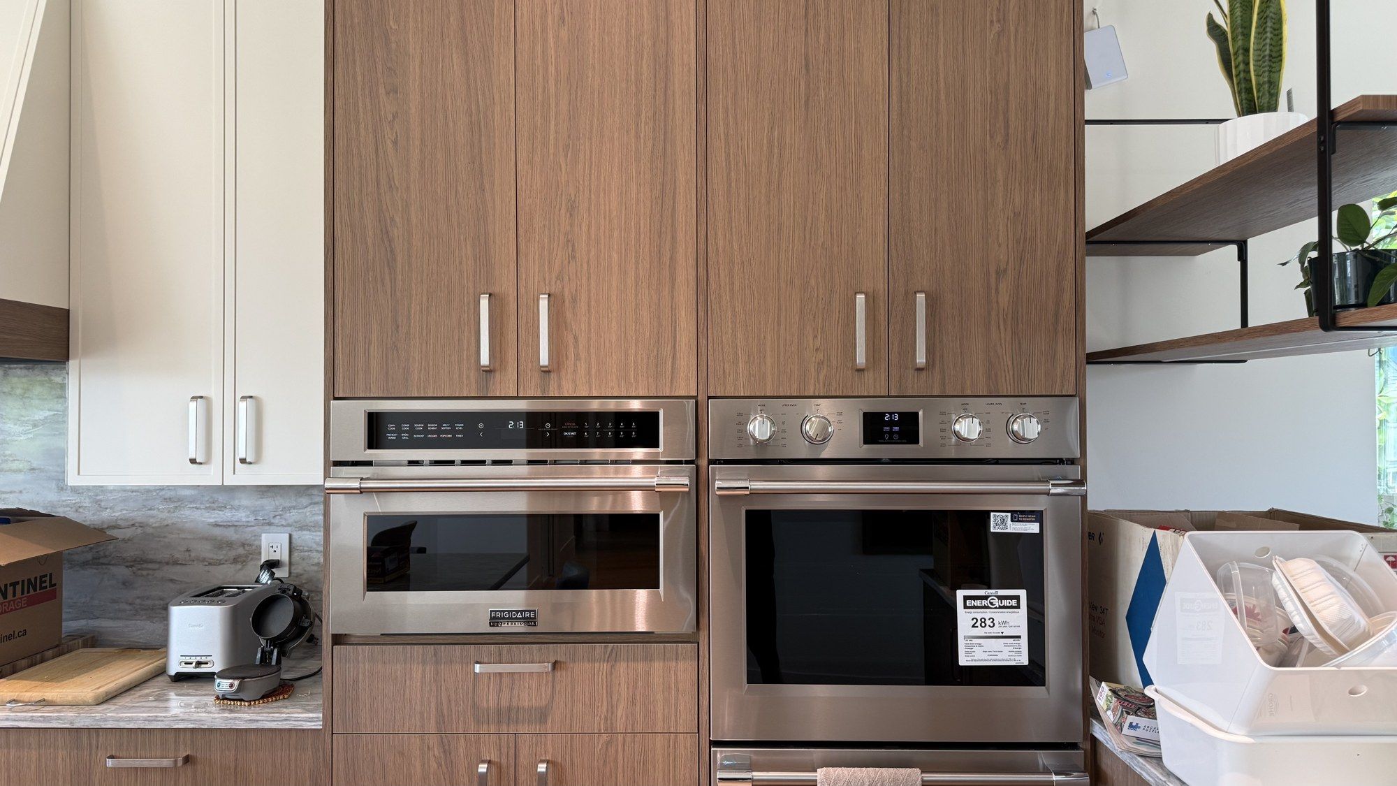 Renovated kitchen with walnut cabinetry and integrated wall ovens in East Vancouver