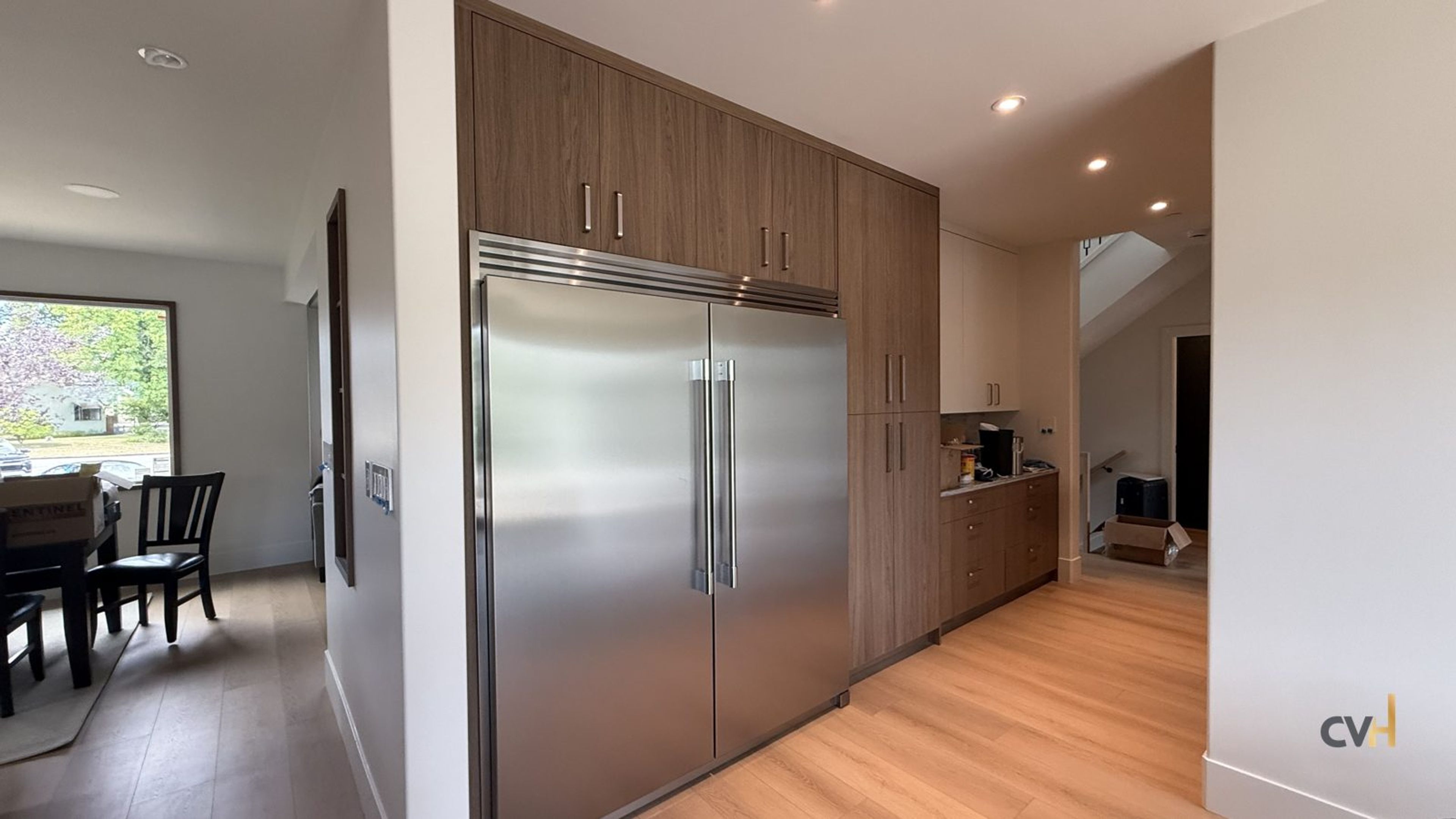 Fitted pantry millwork and integrated refrigerator columns in an East Vancouver kitchen renovation by CoreVal Homes