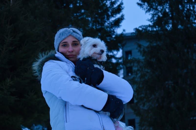 Woman holding dog in winter