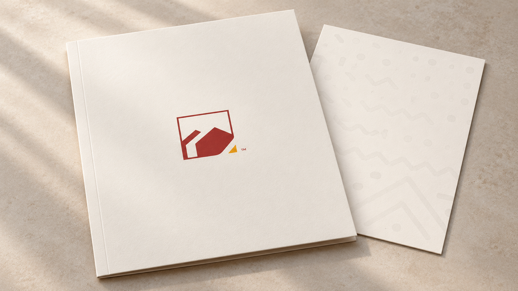 OYNTCDA’s red and yellow identity applied to a cream folder beside a patterned card.