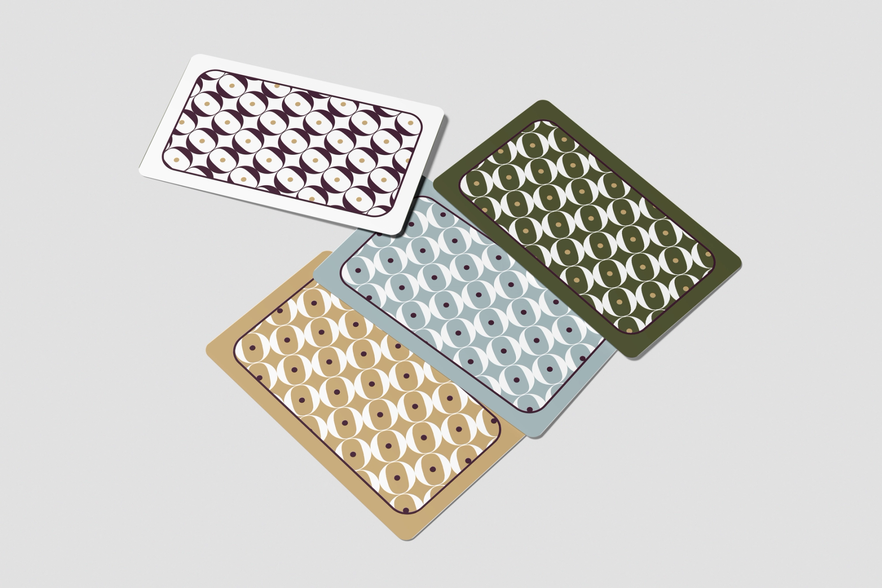 The core visual identity applied to the card backs. The intricate, interlocking geometric pattern, accented with subtle gold dots, is presented across the brand’s four distinct colorways: white with plum, olive green, light blue, and warm tan.