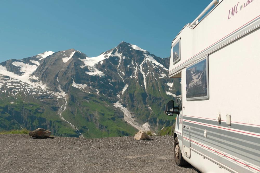 Camper naast besneeuwde bergen tijdens onze reis door Europa