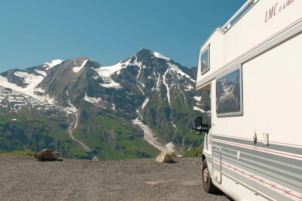 Camper naast besneeuwde bergen tijdens onze reis door Europa