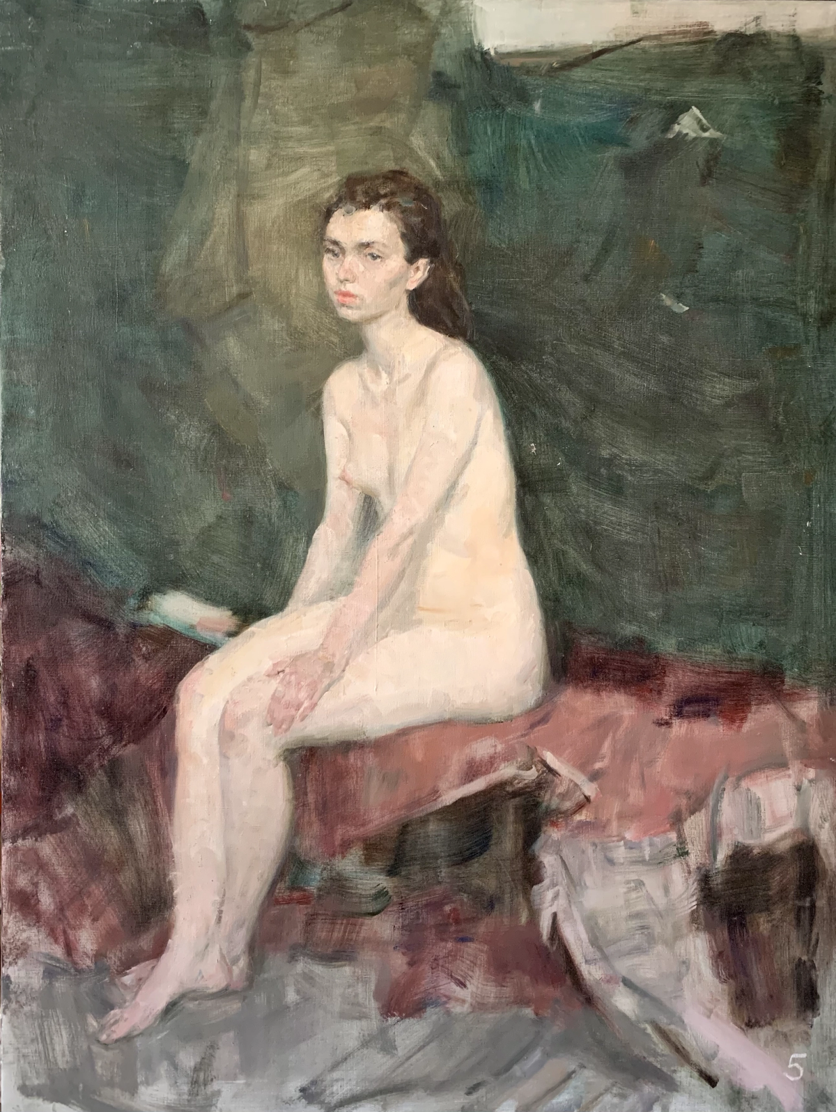 Nude woman seated on a red-covered bench in a dark studio interior.