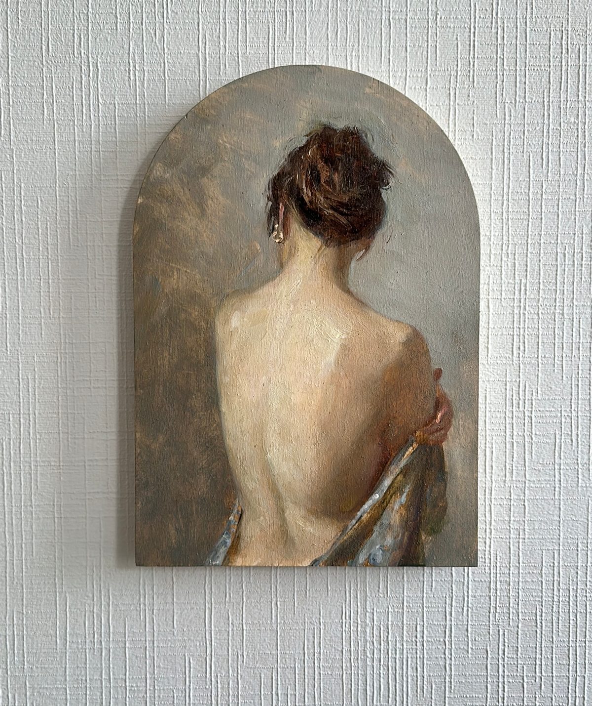 Woman in a white dress resting her head against the back of a chair.