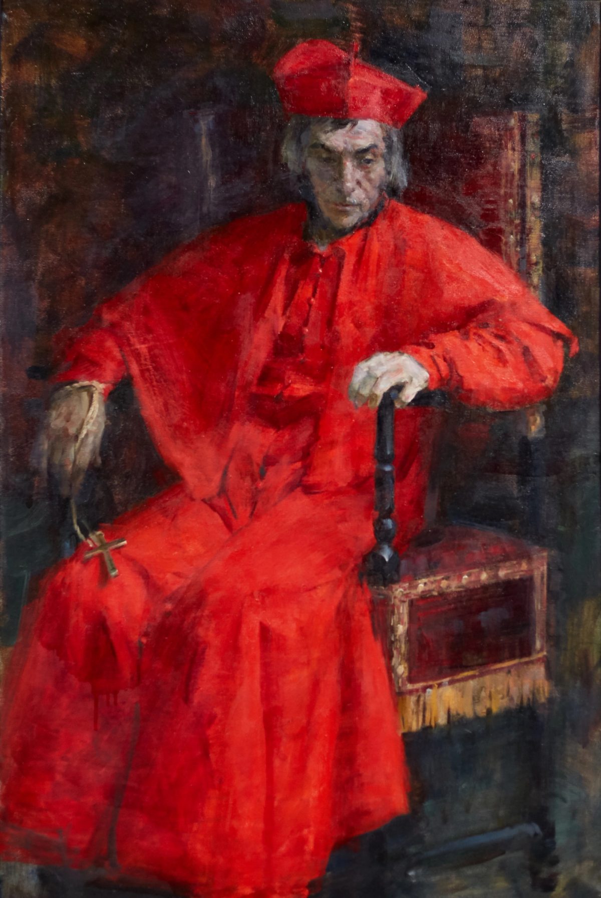 Cardinal in red robes seated with a cross and a cane.