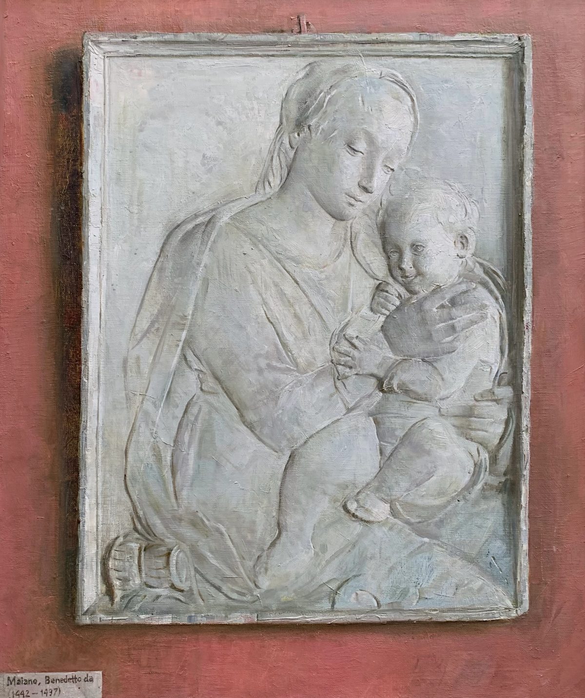 Monochrome painting of a woman holding a child, set in a pale frame.