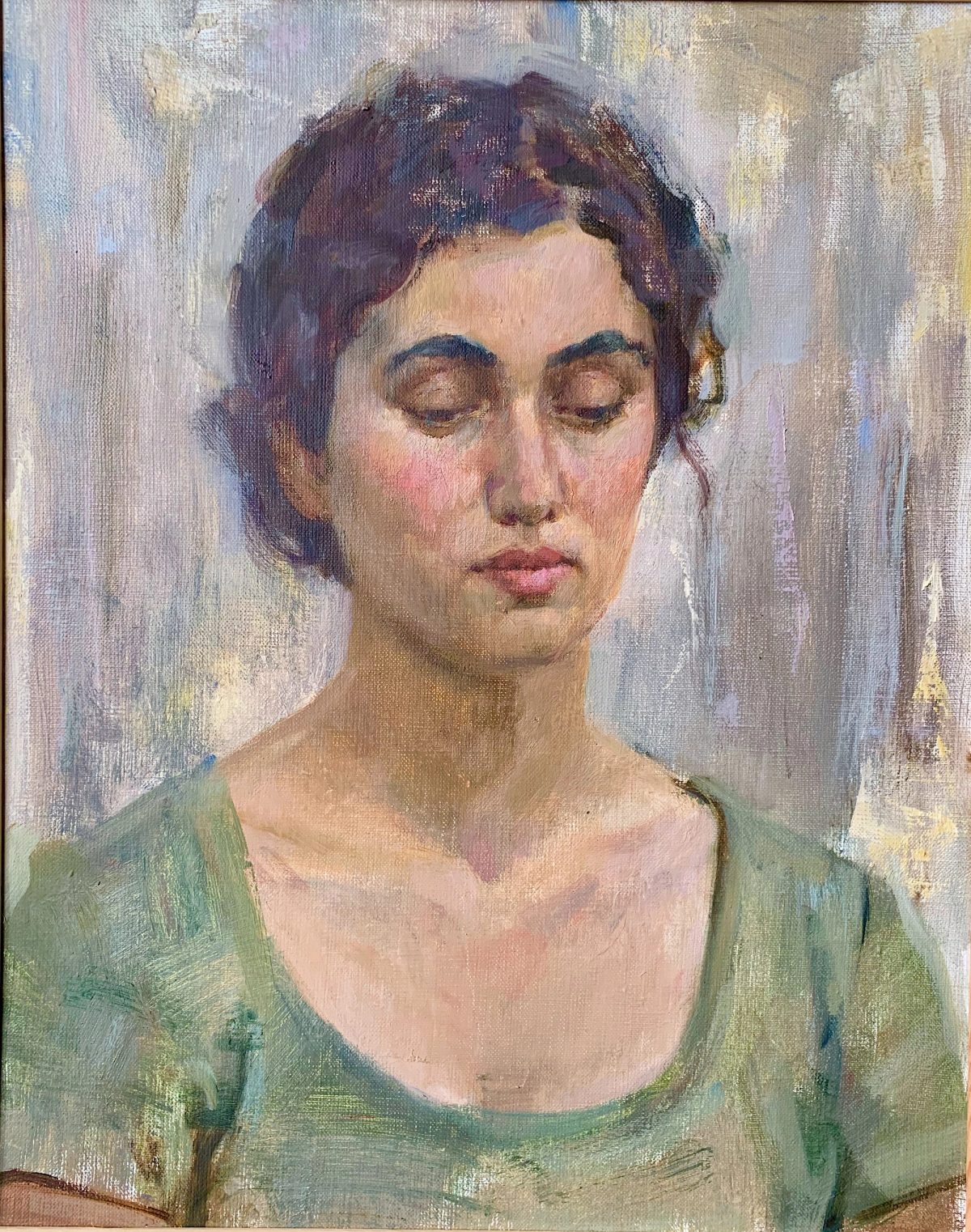 Close-up portrait of a woman with short dark hair against a pale blue and green background.