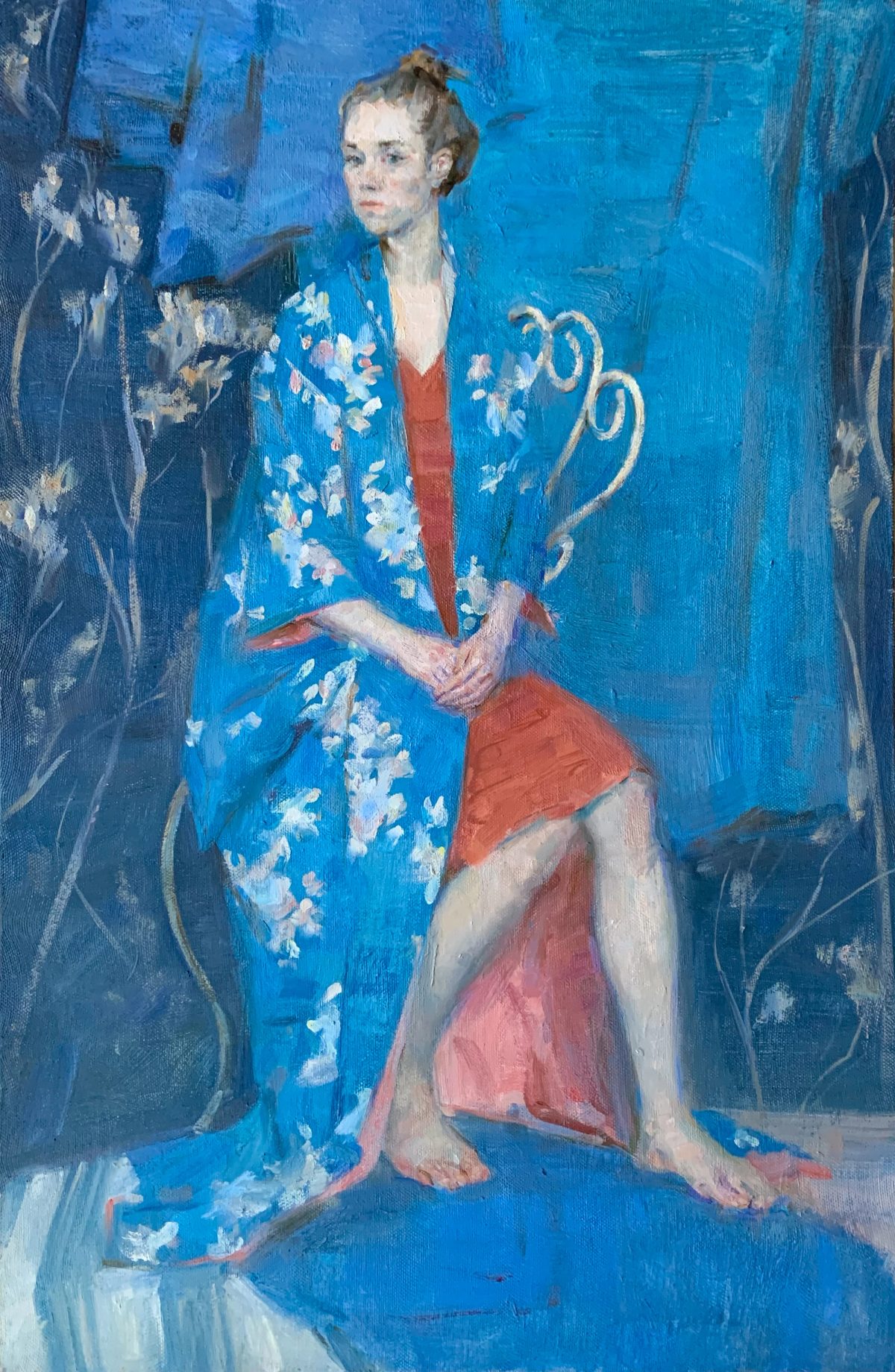 Seated woman in a blue floral kimono and red skirt in a blue interior.