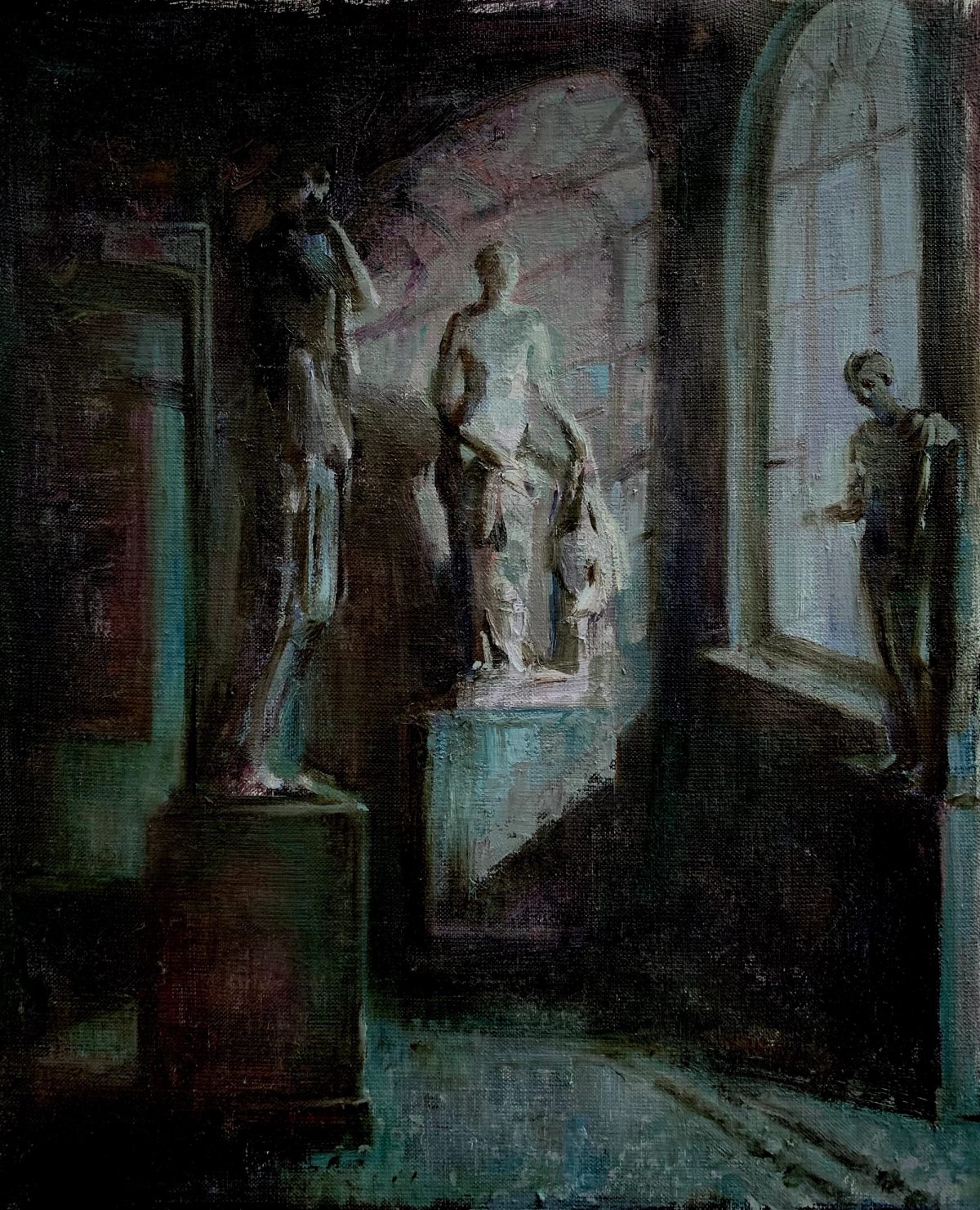 Dimly lit museum interior with sculptures beneath a pale arched window.
