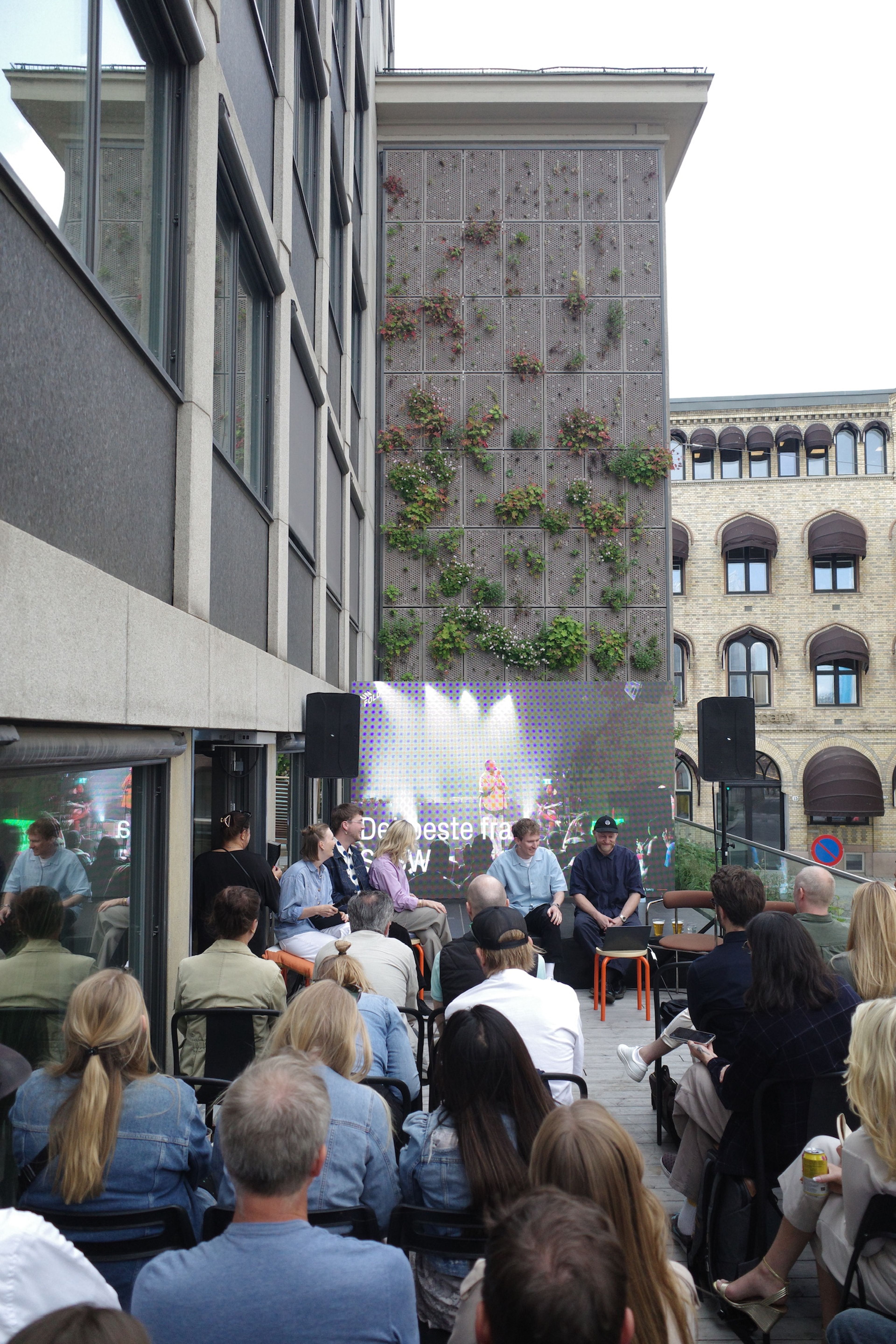 a group of people are sitting in front of a large screen that says " de beste film "