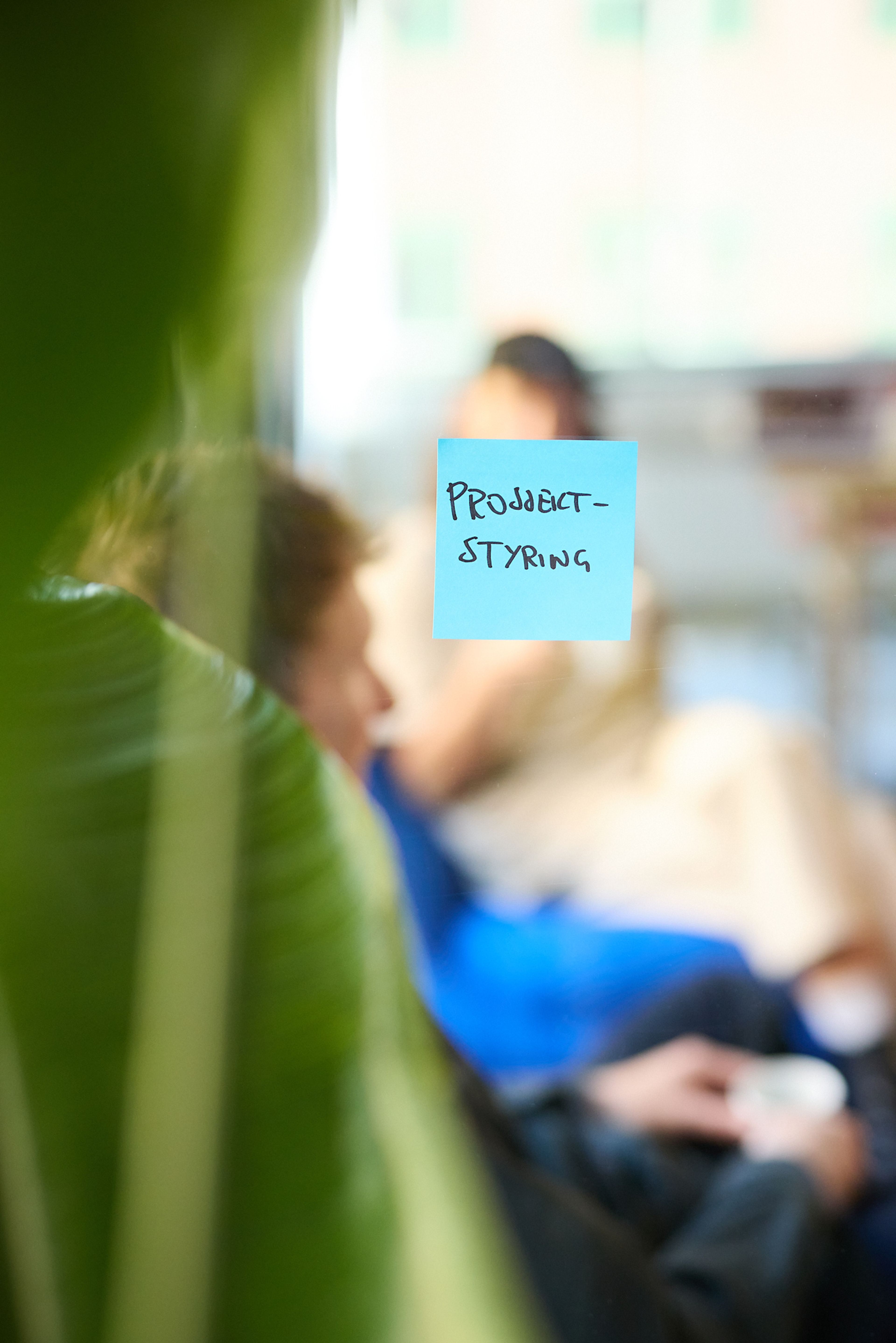 a person is sitting in a chair with a sticky note on the wall that says `` product styling '' .