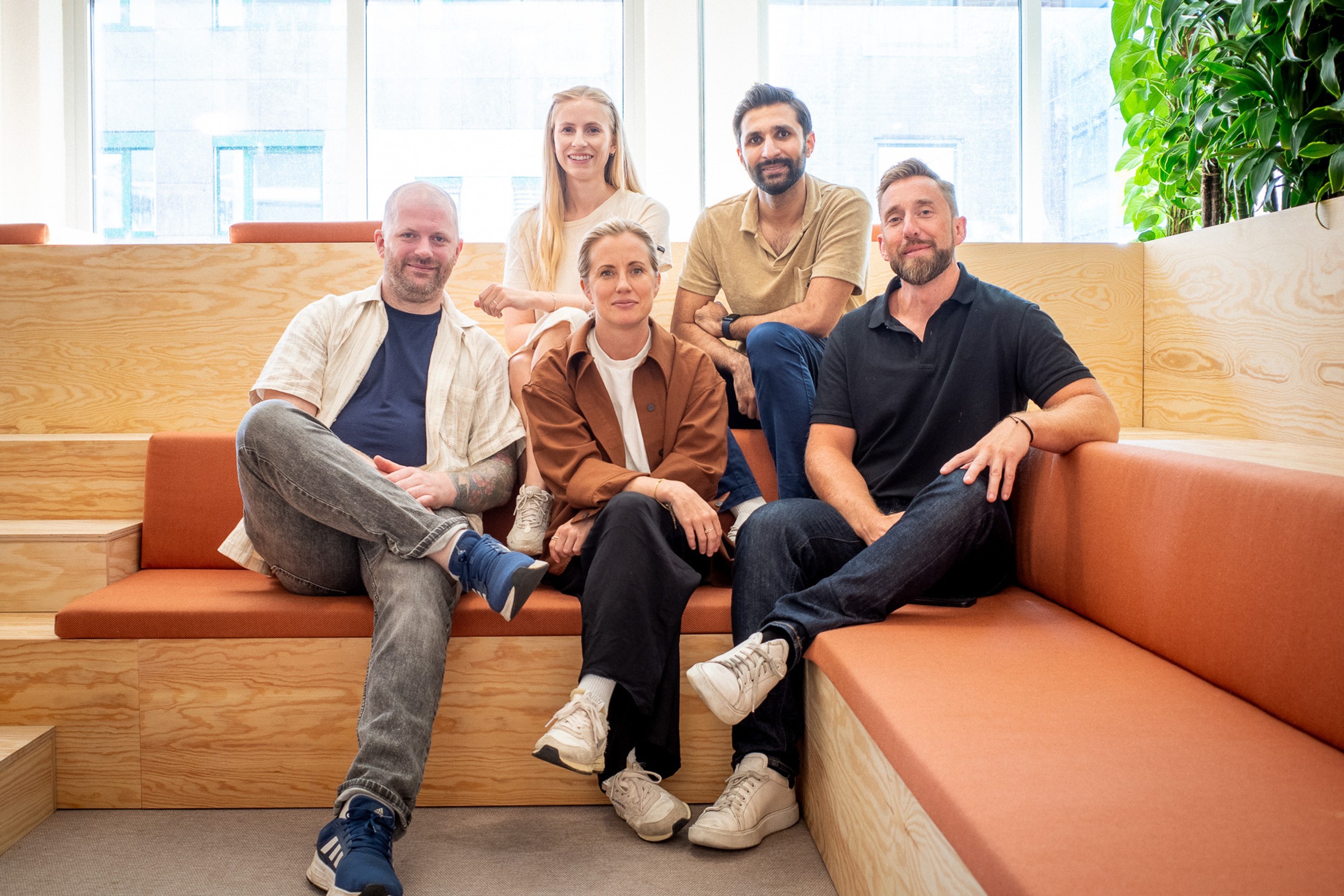 a group of people are sitting on a couch in front of a window .